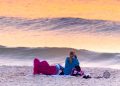 Cape Cod Weather tonight - July 31, 2020. Free Cape Cod News - Photo: Couple watching sunset on Cape Cod beach.